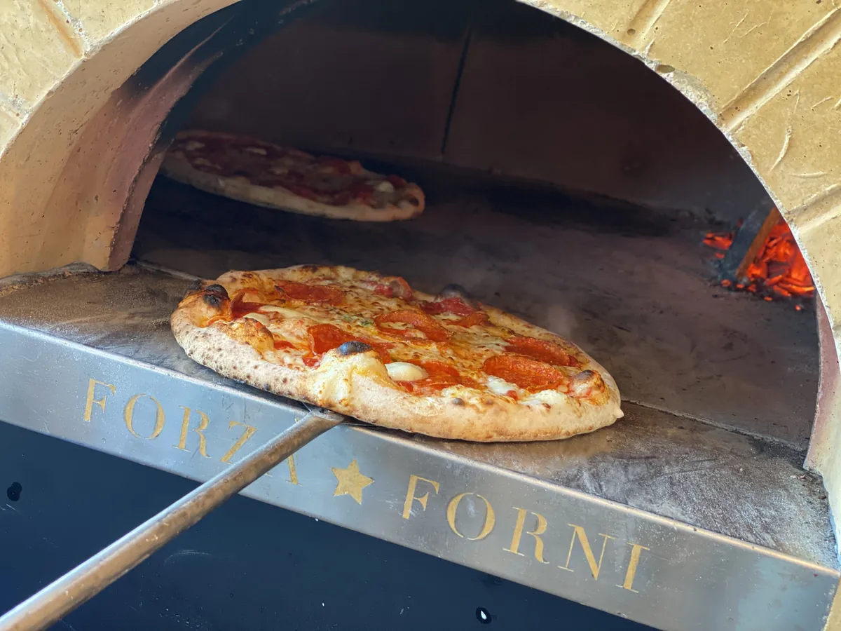 A pizza firing in the wood oven