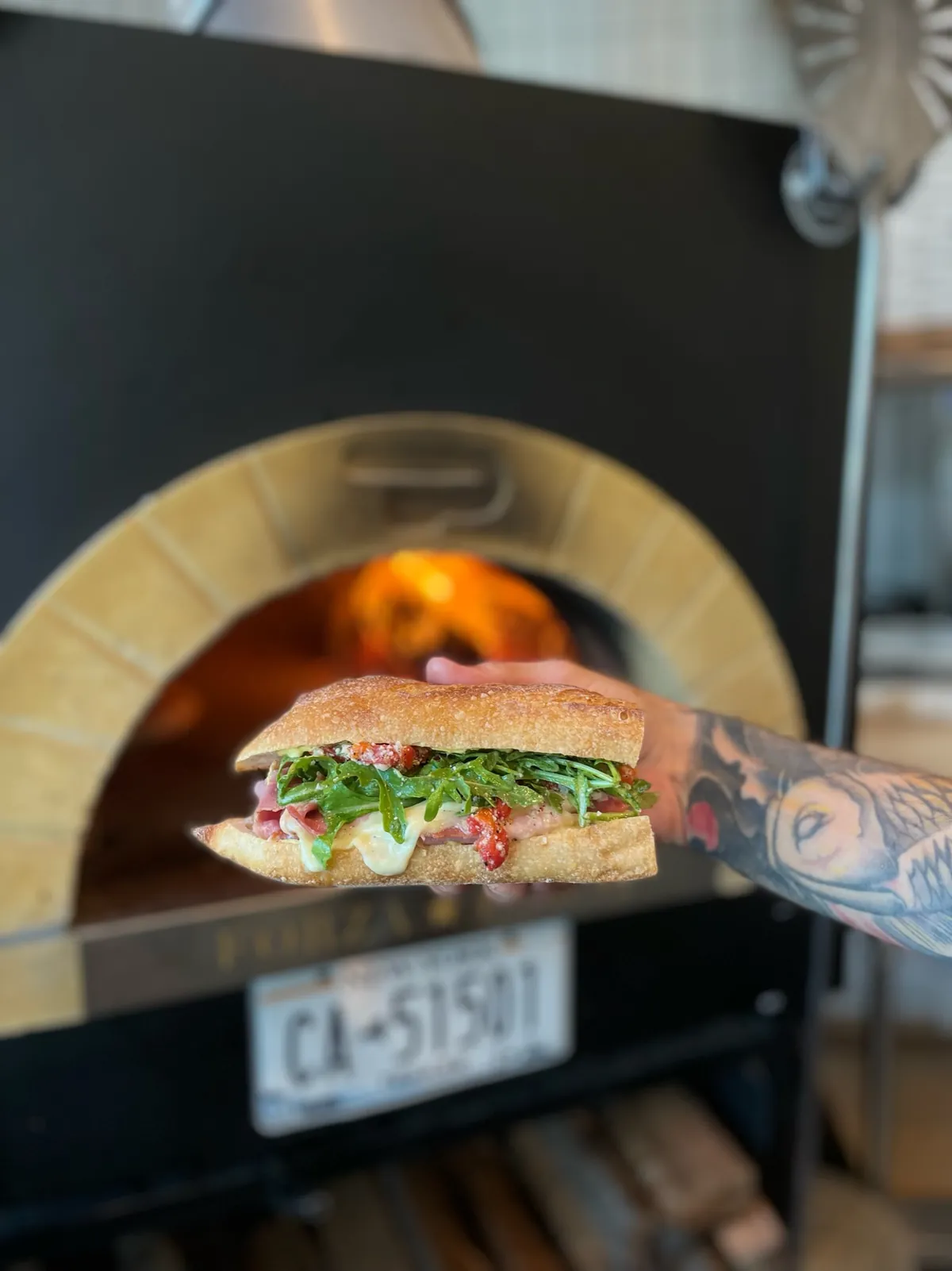 An Italian sub going into the wood-fired oven